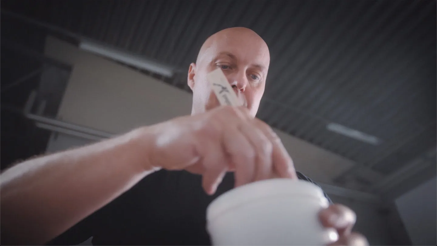 An employee taking a sample from a tub