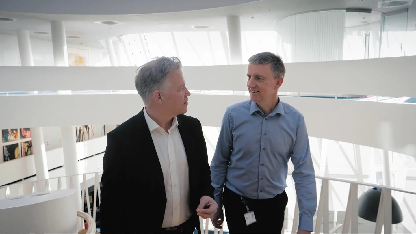 Two men talking on a walkway