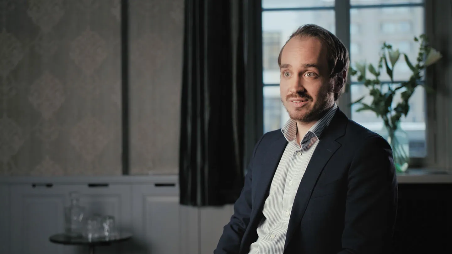 Interview in a dark room with patterned wallpaper